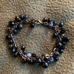 Gorgeous silver bracelet with black beads interspersed with blue beads.